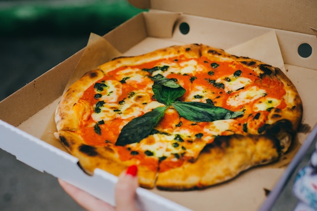 Fresh margherita pizza with basil from a wood-fired food truck oven