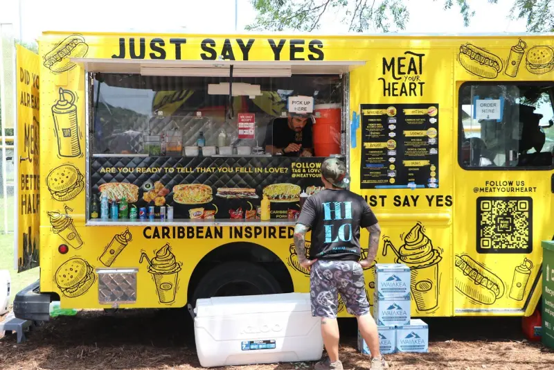 Meat your Heart food truck serving a guest at an outdoor Austin event